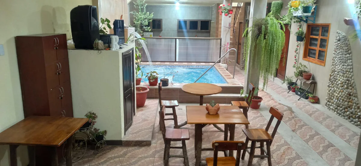 Mesas de madera y plantas junto a la piscina interior de SIRONA.