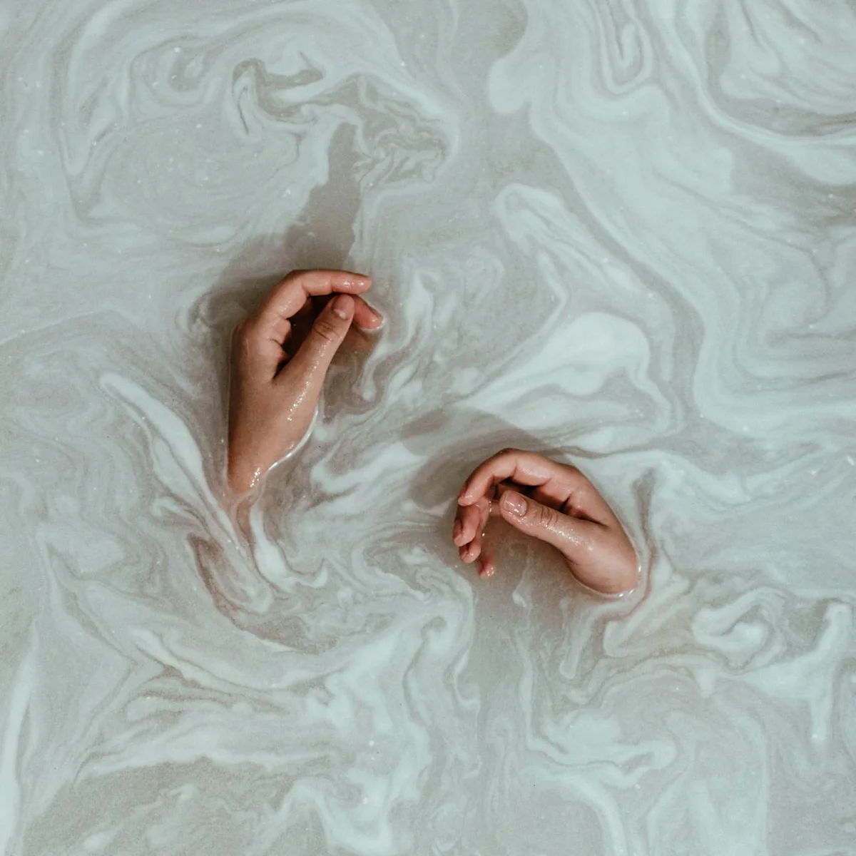 Manos sumergidas en agua con espuma.